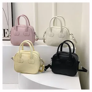 Detail view of four minimalist leather handbags in pink, cream, yellow and black