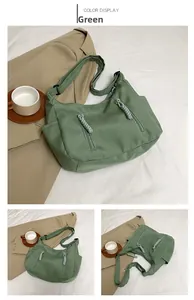 Detail of green nylon tote bag featuring double front zipper pockets and adjustable strap