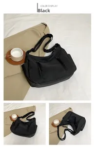 Detail view of black nylon multi-pocket crossbody bag with adjustable strap and casual style