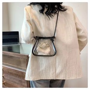 Dettaglio borsa a tracolla in PVC trasparente con finiture nere su un blazer bianco elegante