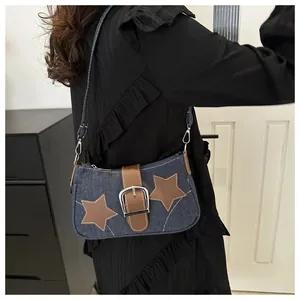 Detail van denim schoudertas met bruine lederen sterren en gespversiering