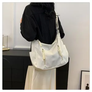 Detailed view of white large capacity tote bag with woven zipper pullers and wide strap