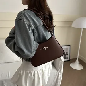 Dark brown leather underarm bag with silver star decor and knotted shoulder strap