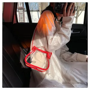 Dettaglio della borsa a tracolla in PVC trasparente con bordi rossi e sacchetto in tela