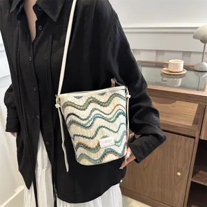 Fashionable bucket bag with colorful wavy weave pattern and white leather shoulder strap
