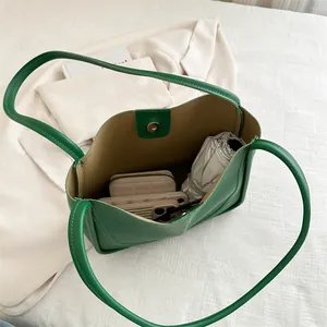 Borsa a secchiello verde in pelle capiente con portafoglio e ombrello all'interno