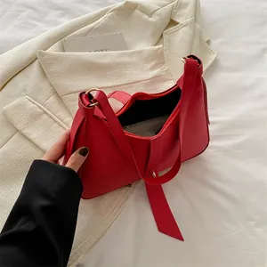 Sac hobo minimaliste en cuir rouge avec ruban de soie et détails en métal doré
