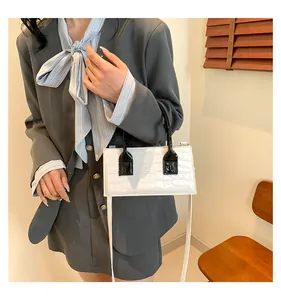 Scatto in stile business di una borsa bicolore con motivo a pietra e tracolla sottile