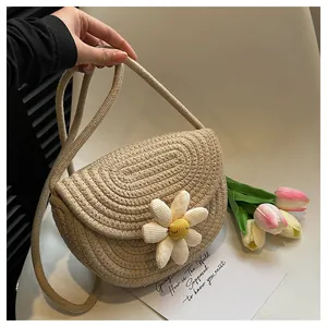 Macro shot of cotton woven texture and 3D daisy flower detail on the beige straw bag