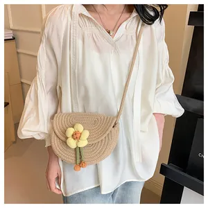 Detailed close-up of a handmade beige crochet saddle bag with a 3D yellow flower ornament