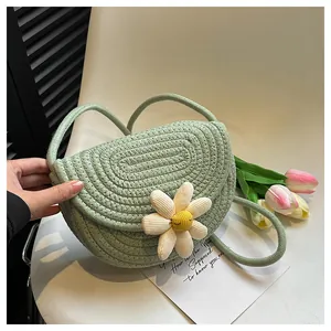 Macro detail of handwoven light green daisy shoulder bag with soft textured floral petal