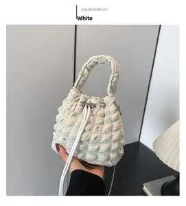 Detail of white bubble texture fabric on drawstring bucket bag with chain strap