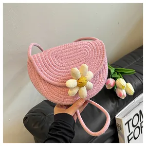 Detail of pink woven cotton crossbody bag featuring a 3D sunflower and braided rope strap