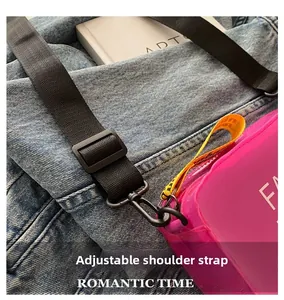 Detail of adjustable black nylon strap with metal hooks on pink transparent jelly bag