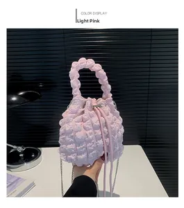 Detail showing light pink pleated texture on a cloud bag with silver chain strap