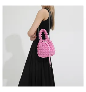 Pink quilted bubble puff shoulder bag with silver metal chain strap shown on model