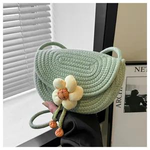 Detail of light green cotton woven bag featuring a yellow 3D flower and tassel accents