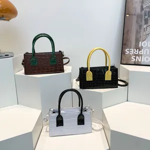 Tre eleganti borse con motivo a pietra e colori a contrasto su supporti geometrici bianchi