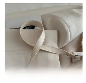 Détail de la bandoulière en cuir PU et boucle métallique du sac baguette couleur crème