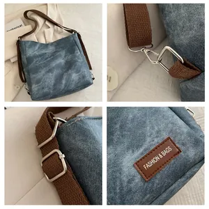Detail view of retro denim shoulder bag featuring adjustable straps and silver metal hooks