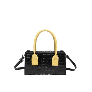 Borsa bicolore con motivo a pietra in nero e giallo con tracolla regolabile a contrasto