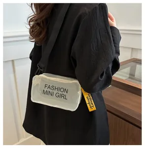 Detail view of transparent PVC crossbody bag with Fashion Mini Girl text and yellow strap