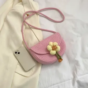 Pink woven flower shoulder bag with a yellow fabric floral design and crossbody rope strap