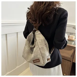 Close-up of denim backpack side pocket with brown leather fashion label and metal hardware