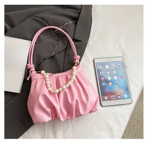 Pink pleated cloud bag size comparison with tablet showing capacity and pearl handle