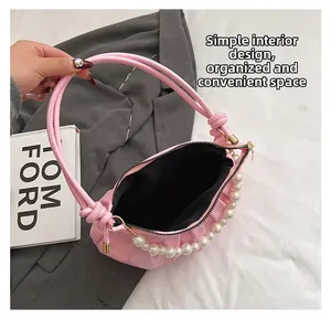 Detailed interior of a pink pearl chain bag with black lining and smooth zipper design
