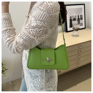 Détail du sac baguette vert vif avec boucle étoile argentée et texture en cuir lisse