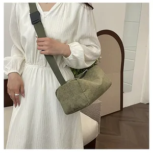 Close-up of olive green corduroy crossbody bag with adjustable wide fabric strap