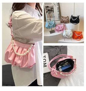 Detail showing pleated cloud bag with pearl chain handle and interior storage capacity