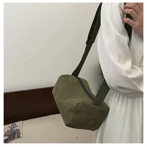 Detail view of dark green corduroy crossbody bag with adjustable wide strap for daily use