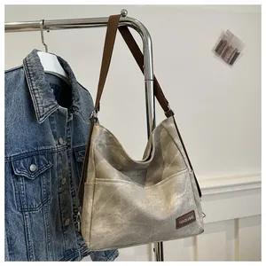 Close-up of vintage canvas tote bag with side pocket and brown leather logo tag