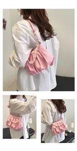 Detailed view of pink pleated cloud bag featuring large pearl chain and soft leather texture