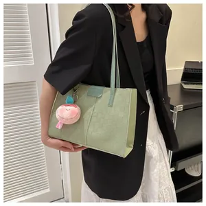 Detail of light green tote bag with checkered texture and fashion leather patch