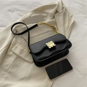 Sac à bandoulière noir avec rabat ondulé, fermoir ours doré et bandoulière chaîne