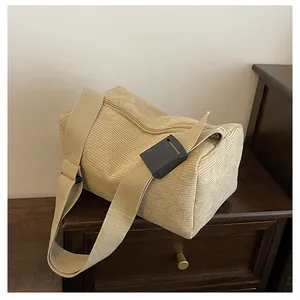 Detailed close-up of beige corduroy fabric texture and zipper on a stylish crossbody bag