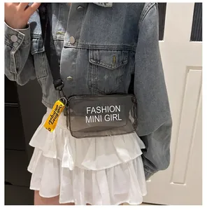 Detail of transparent smoke grey PVC crossbody bag with wide strap and fashion lettering