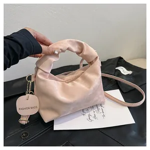 Pink pleated cloud bag detail showing velvet texture and fashion bag decorative tag