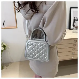 Detail of silver quilted handbag showing metallic texture and rhombic pattern stitching