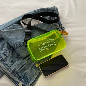 Neon yellow transparent PVC jelly crossbody bag with adjustable black strap and slogan print