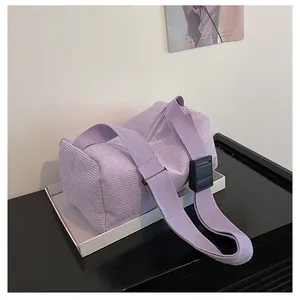 Detail of light purple corduroy texture and wide strap on minimalist cylinder bag