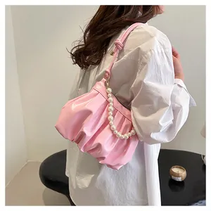 Pink pleated cloud shoulder bag with luxury pearl chain strap on model with white shirt