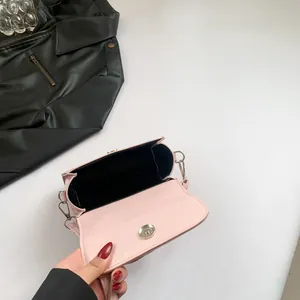 Pink leather crossbody bag with silver hardware and bow detail shown from a top view