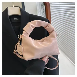 Detail of pink pleated cloud bag showing velvet texture and gold metal hardware link