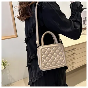 Detail shot of a cream quilted crossbody bag with soft bubble texture on a model