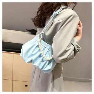 Detail view of light blue pleated cloud bag featuring pearl chain and soft PU leather texture