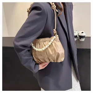 Detail showing the pleated cloud bag with pearl chain and adjustable shoulder strap